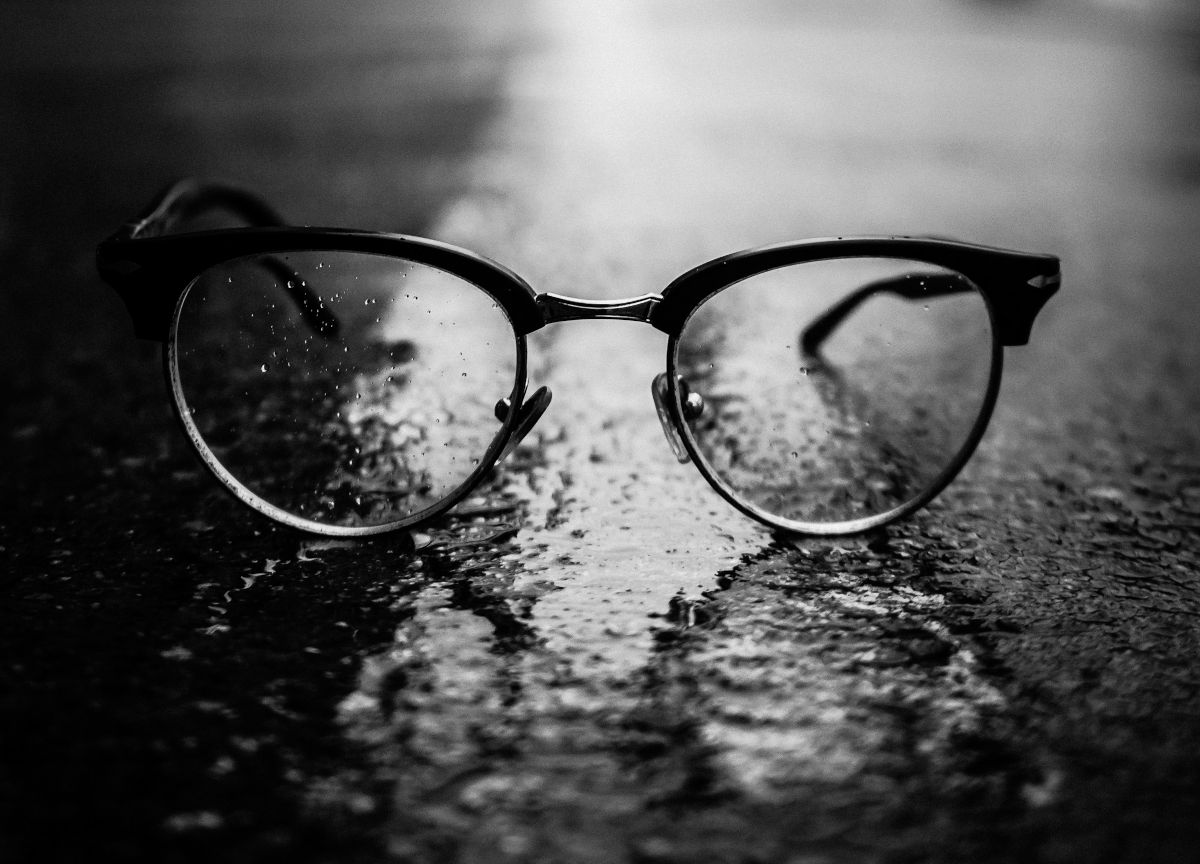 Graustufenfotografie von Sonnenbrillen im Clubmaster-Stil auf der Straße